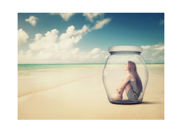 Girl in a jar sat on a beach